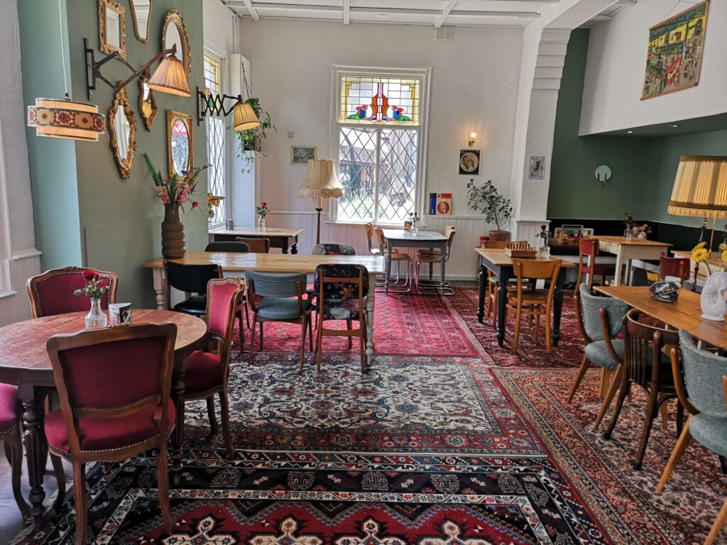 Het kleurrijke interieur van Knus Bussum met verschillende stoelen en Perzische kleden